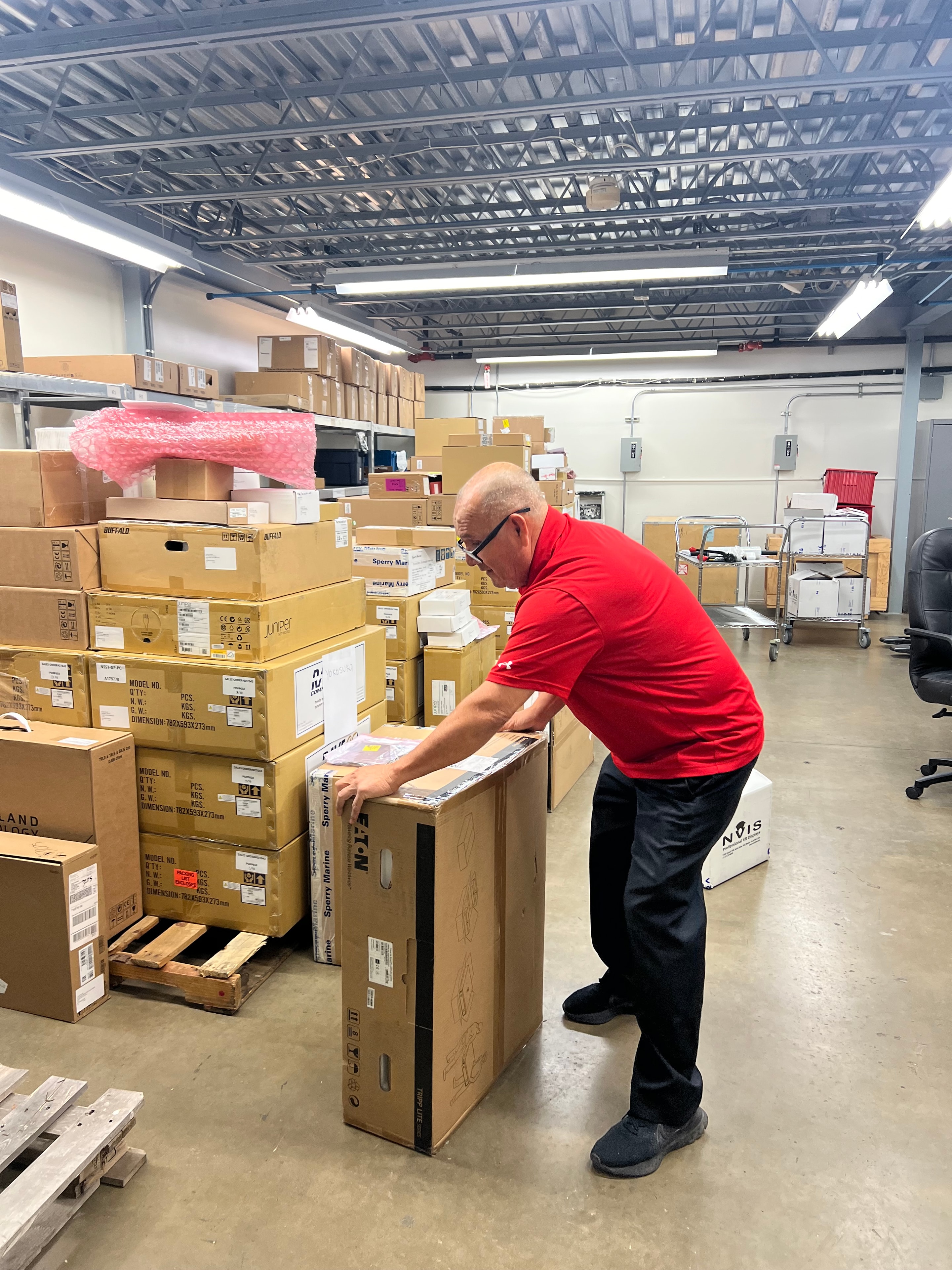 JIRACOR personnel performing hands-on material handling, inspection, and order preparation at the Orlando warehouse facility