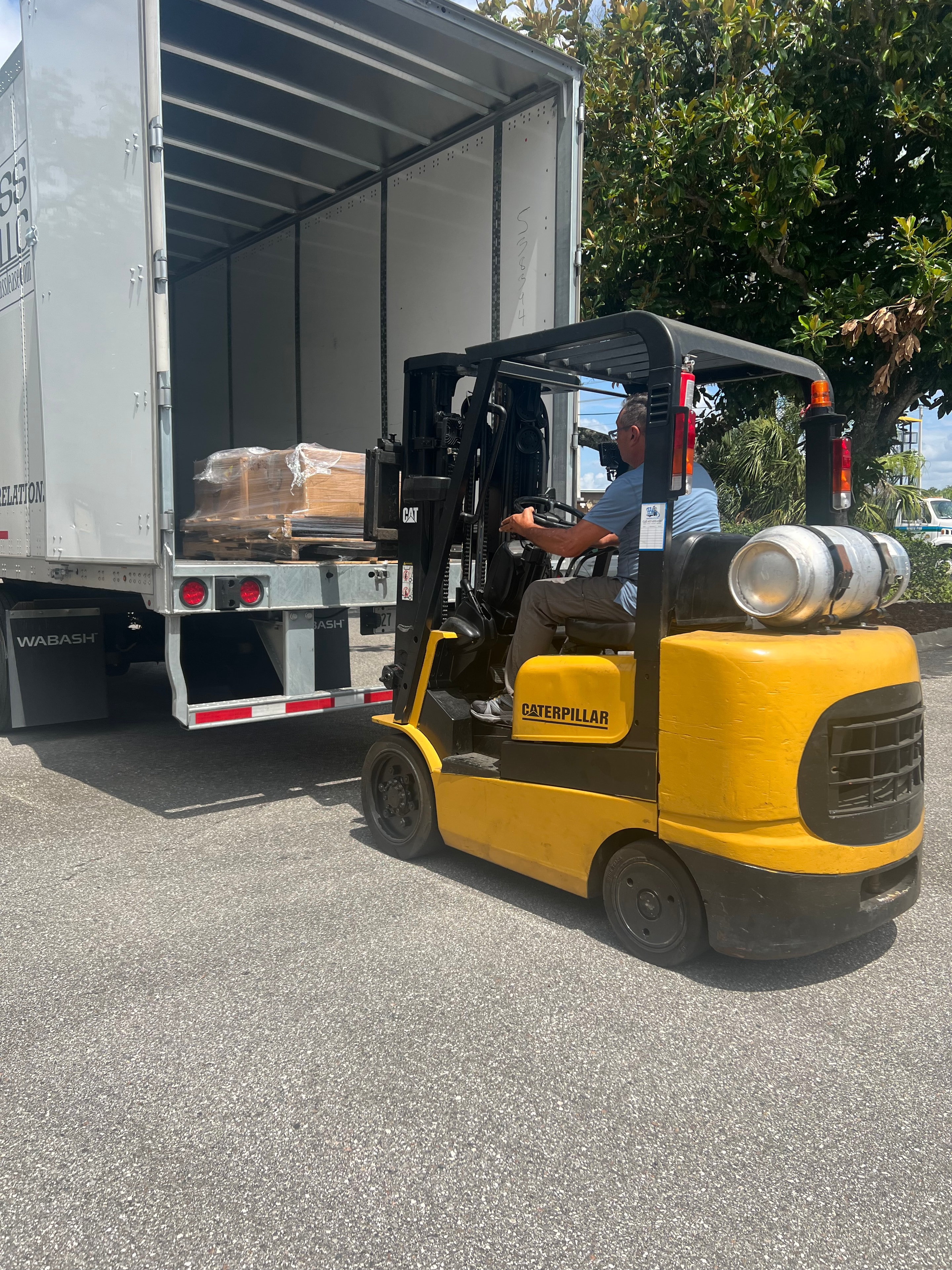 Palletized technical equipment being handled by Caterpillar forklift for transportation and delivery