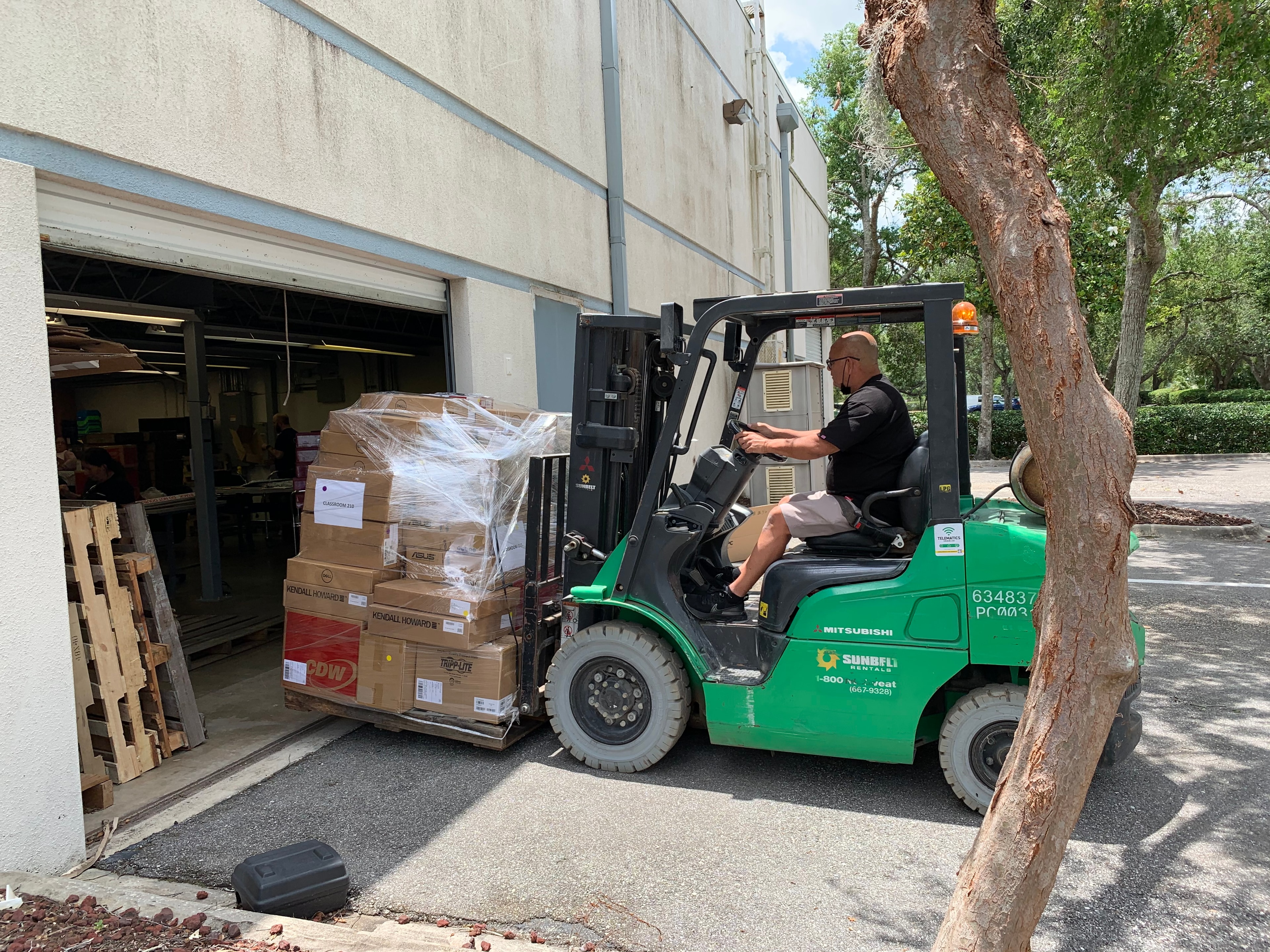 JIRACOR team member operating forklift to load palletized equipment for program shipment