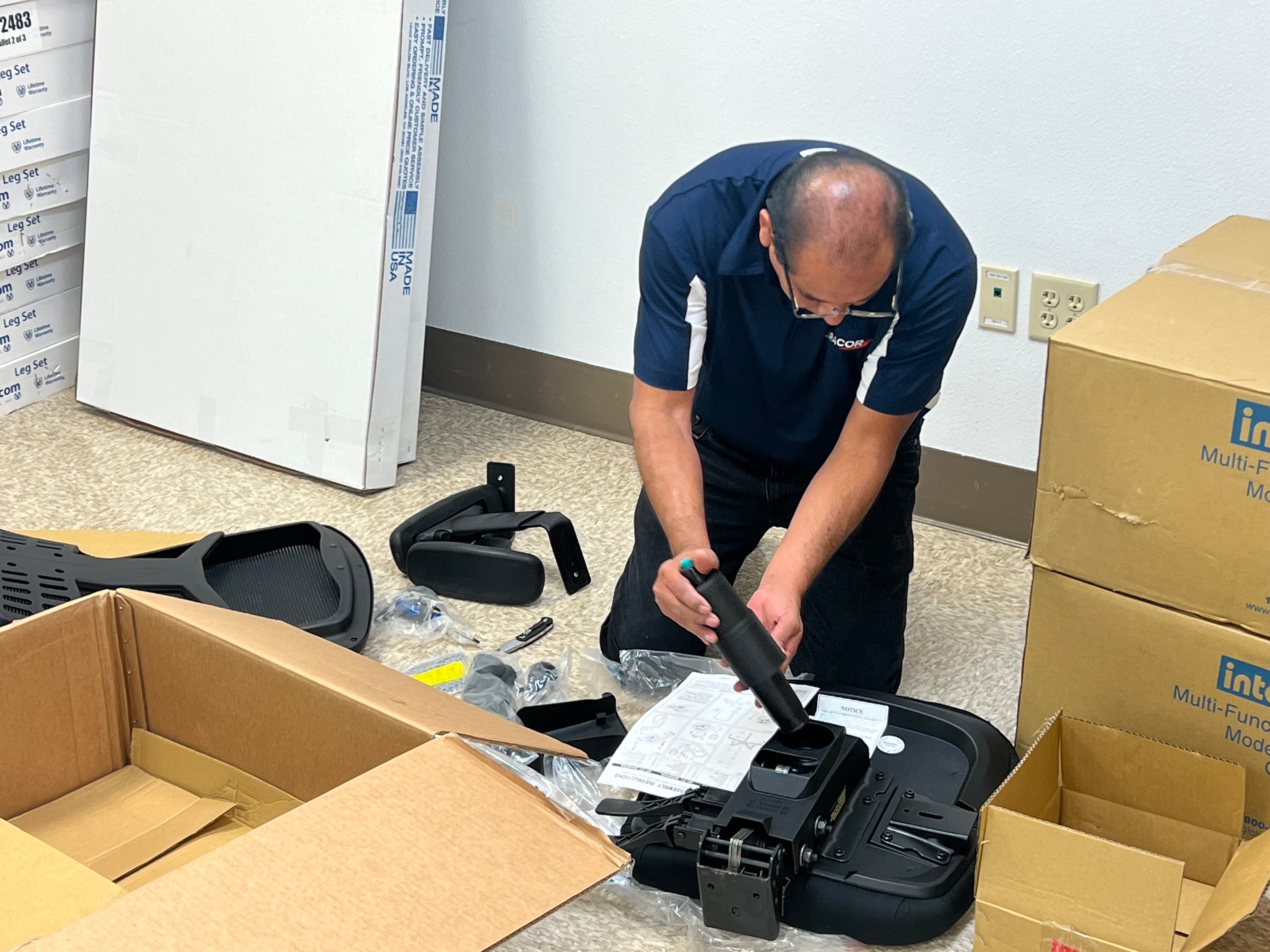 JIRACOR personnel in branded polo assembling and preparing training system equipment components for installation and integration