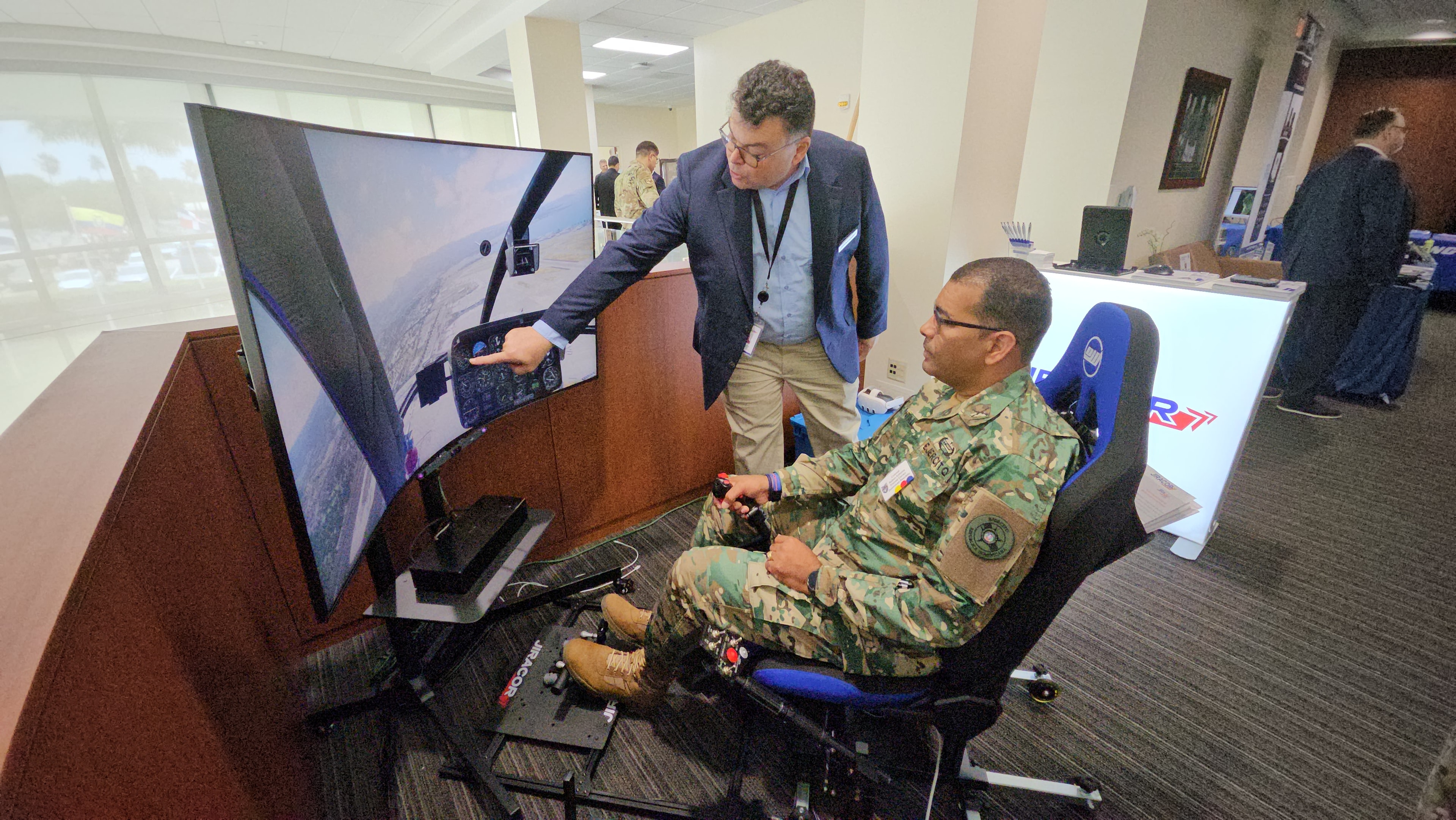 Military participant operating the JIRASIM™ JL1000 flight training simulator with JIRACOR representative